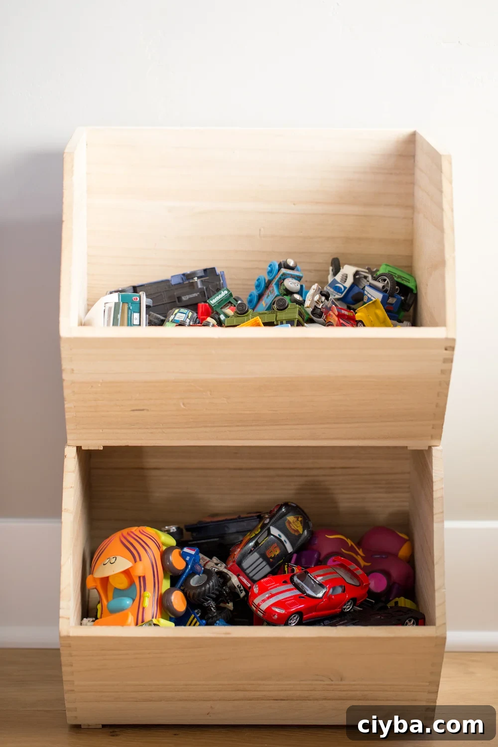 stacked wooden toy storage boxes with toy cars inside