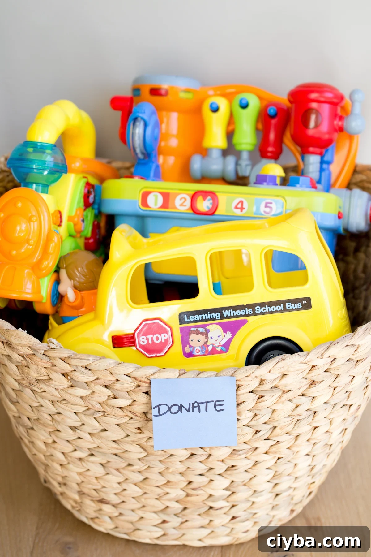 closeup of plastic toys in a woven basket with a "donate" sticker on it