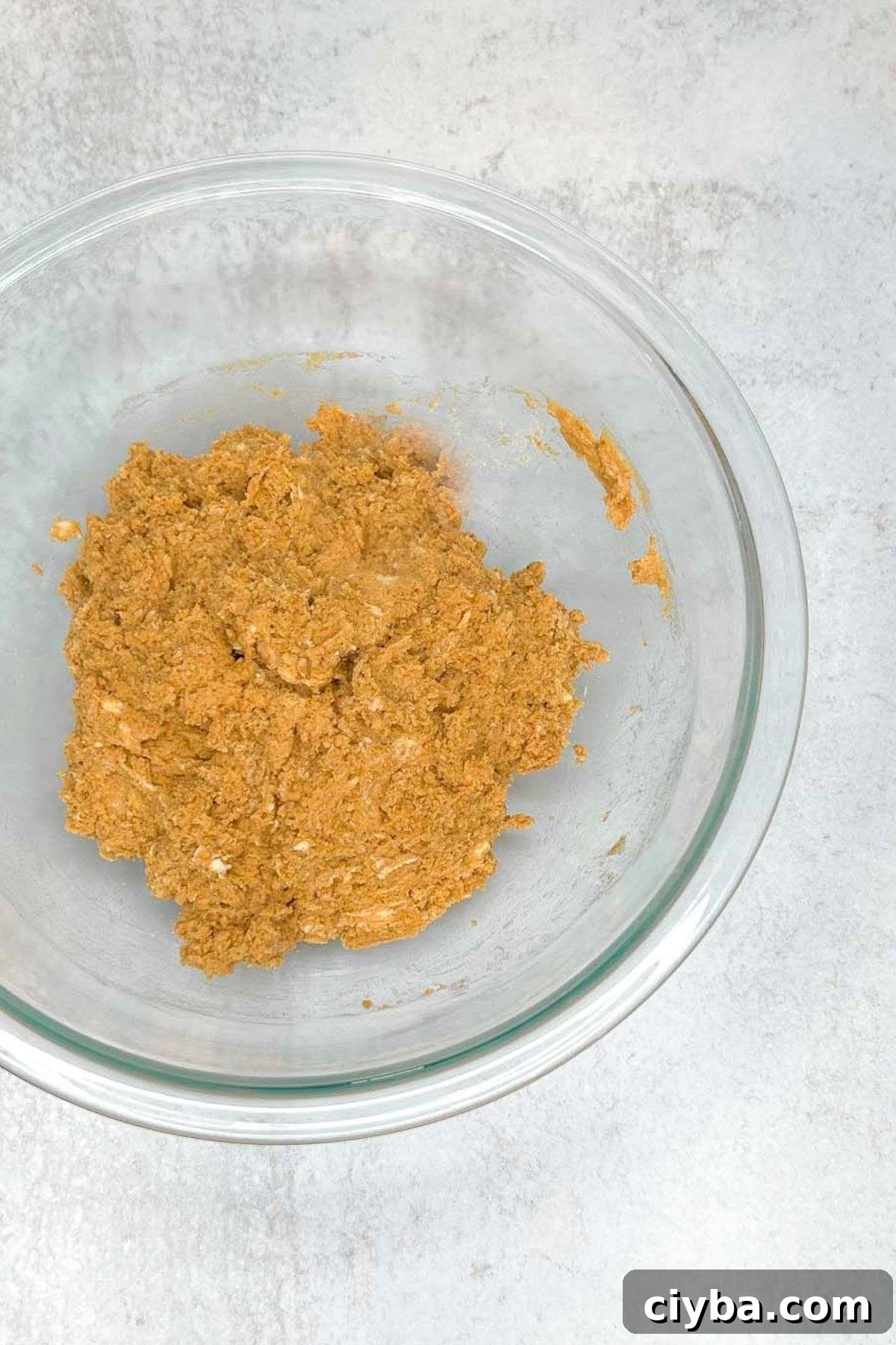 Mixed pumpkin scone dough in a glass mixing bowl.