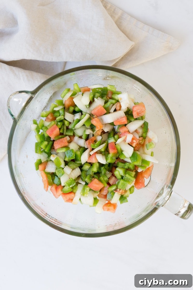 Tomatoes, onions and capsicum chopped in a bowl