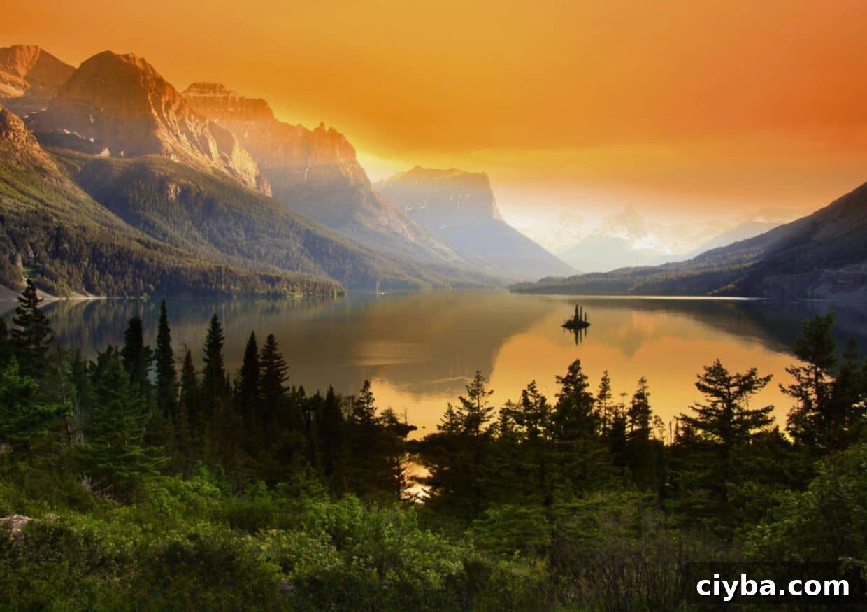 Sunset over a tranquil mountain lake in Montana with vibrant orange skies and silhouetted peaks.
