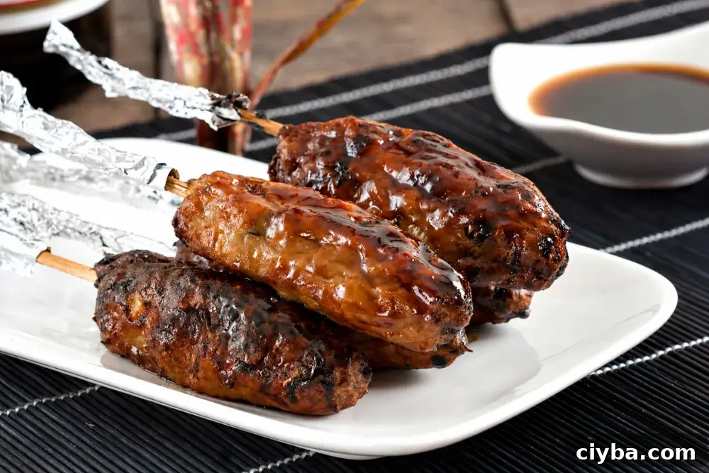 Tsukune chicken skewers brushed with glossy yakitori sauce after grilling.