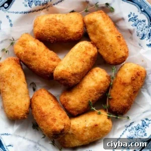 A close up cropped image of chicken croquettes in a blue and white bowl.