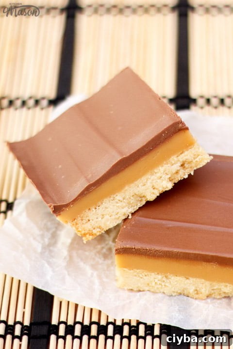 Millionaire's shortbread bar leaning on another bar on scrunched up white baking paper