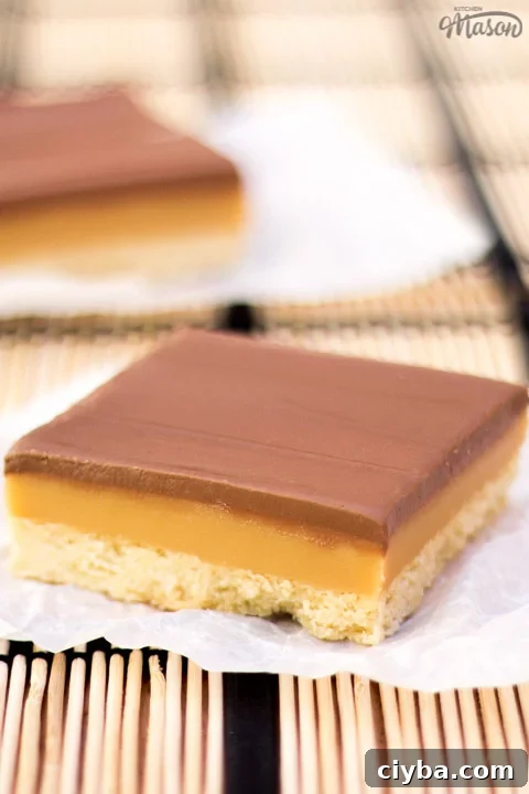 A bar of millionaire's shortbread on a scrunched up piece of white baking paper.