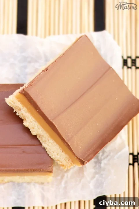 Millionaire's shortbread bar leaning on another bar on scrunched up white baking paper