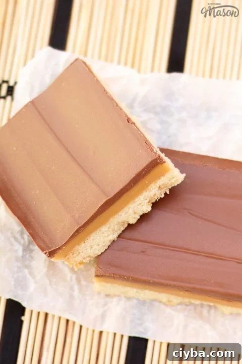 Millionaire's shortbread bar leaning on another bar on scrunched up white baking paper