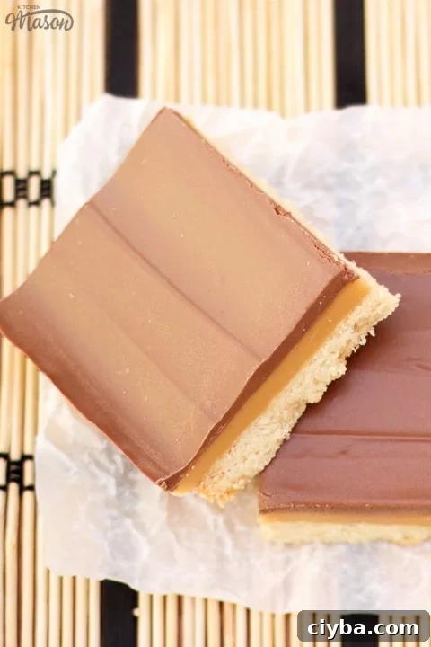 Millionaire's shortbread bar leaning on another bar on scrunched up white baking paper