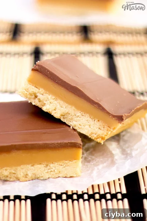 Millionaire's shortbread bar leaning on another bar on scrunched up white baking paper
