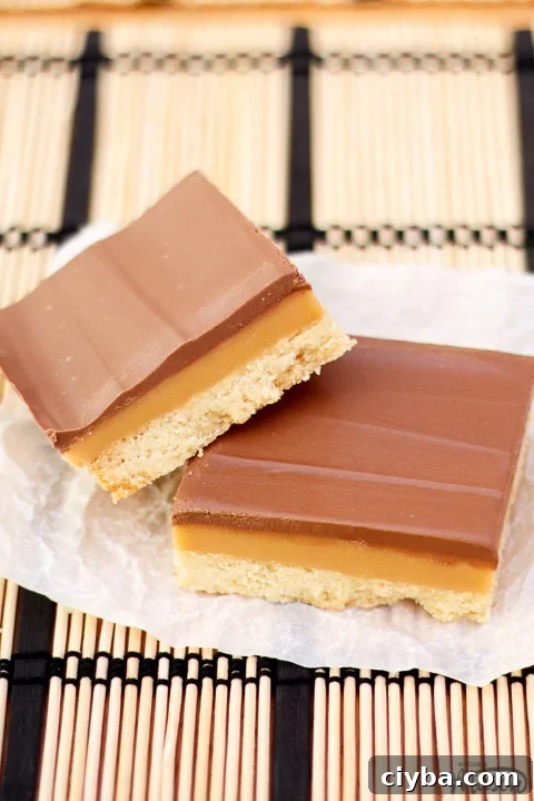 Millionaire's shortbread bar leaning on another bar on scrunched up white baking paper