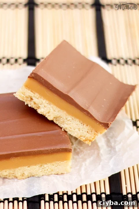 Millionaire's shortbread bar leaning on another bar on scrunched up white baking paper