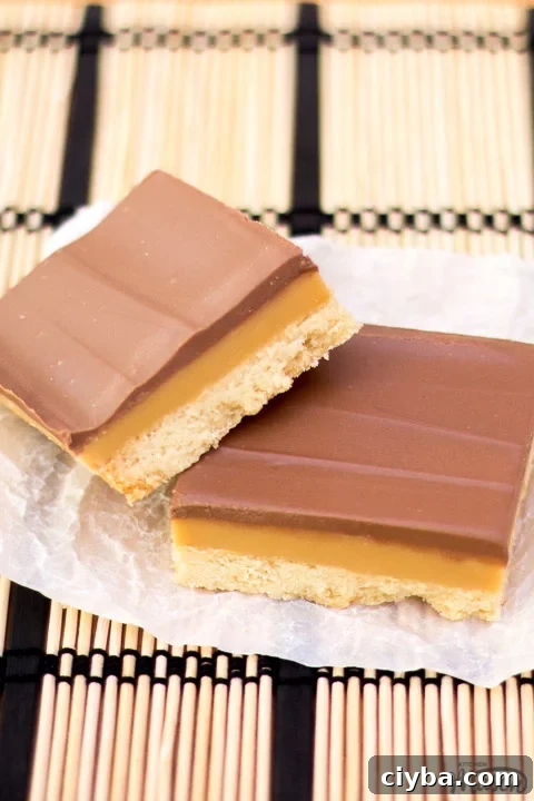 Millionaire's shortbread bar leaning on another bar on scrunched up white baking paper