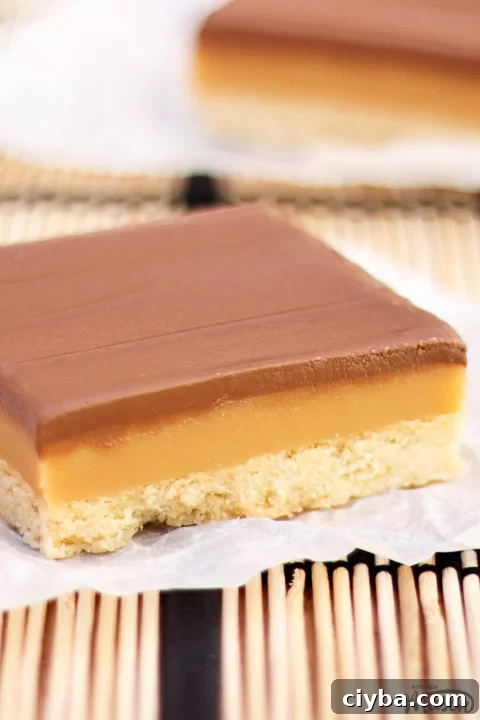 A bar of millionaire's shortbread on a scrunched up piece of white baking paper.