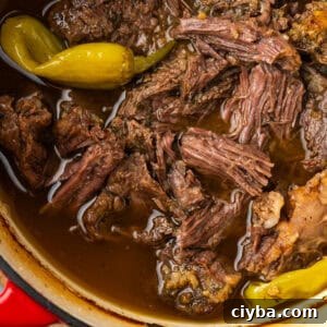 Mississippi pot roast topped with peperoncini in a Dutch oven pot.