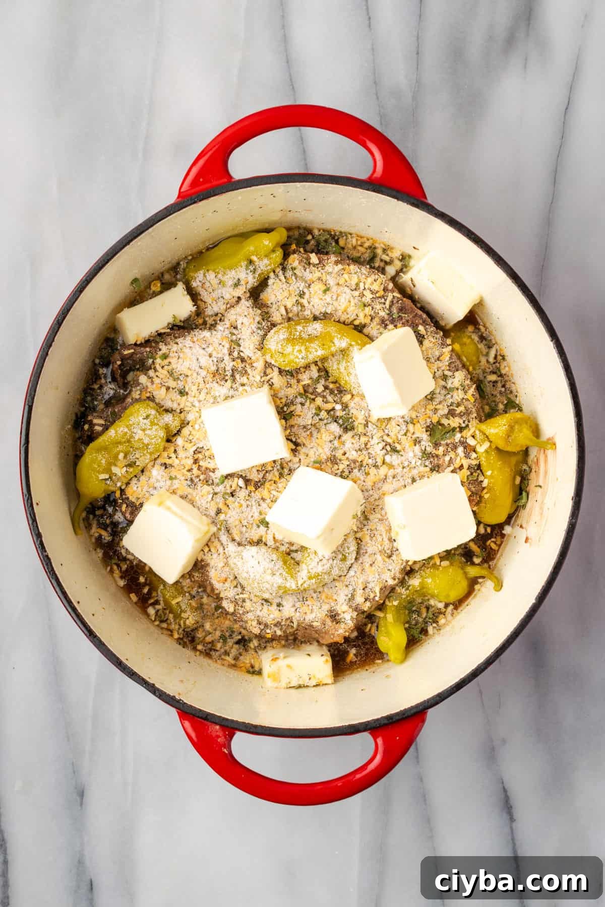Milk powder, herbs, spices and cubes of butter added on top of the pot roast.