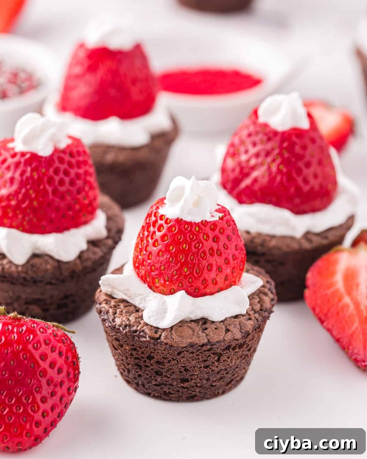 Santa Hat Brownies: Festive Chocolate Holiday Treats 2 several santa hat brownie bites on a table.