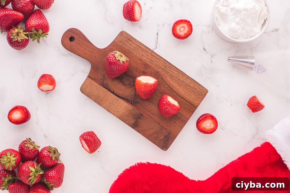 Santa Hat Brownies: Festive Chocolate Holiday Treats 9 strawberries with the top sliced off are lined up on a cutting board.