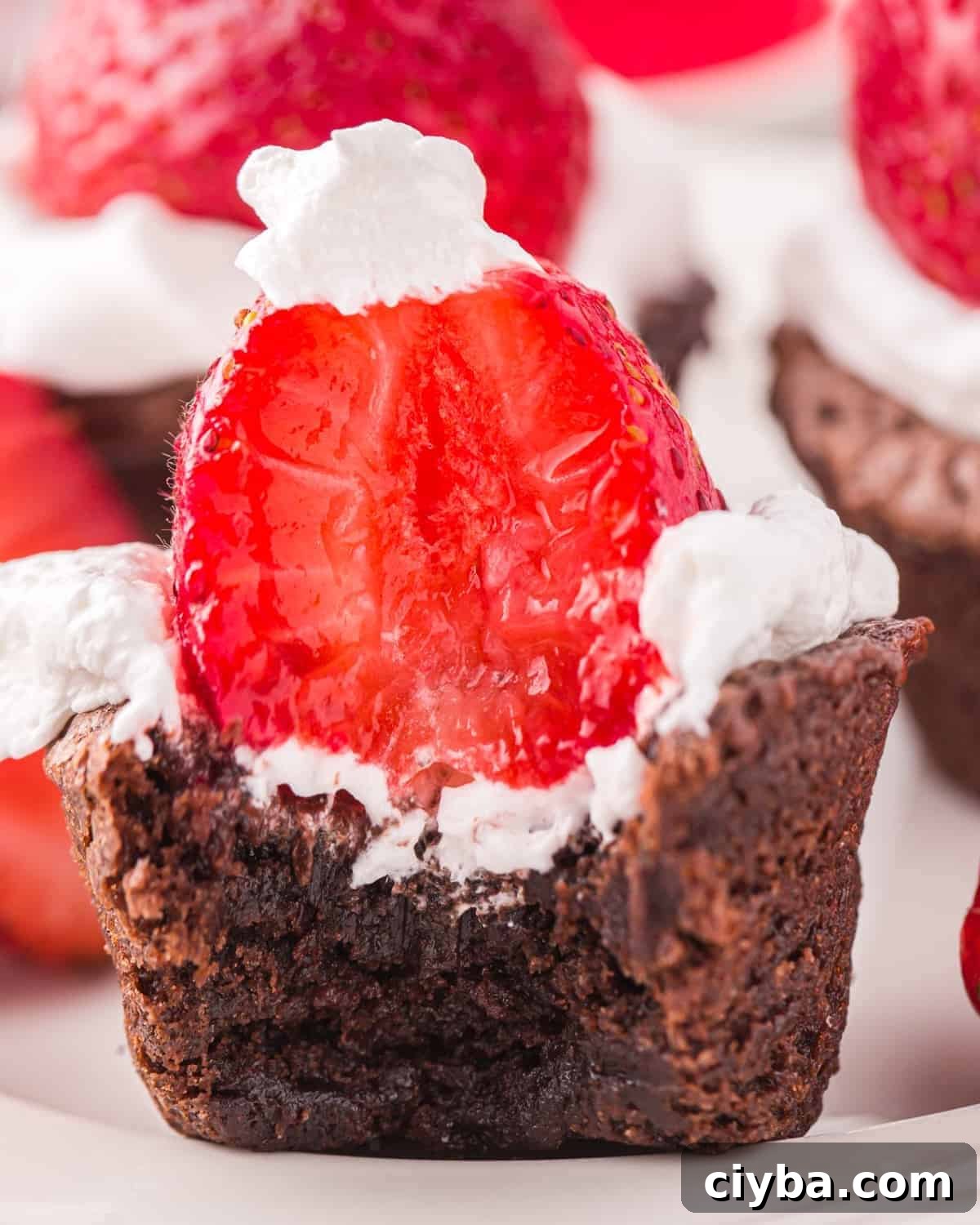 Santa Hat Brownies: Festive Chocolate Holiday Treats 3 side view of a bitten strawberry santa hat brownie.
