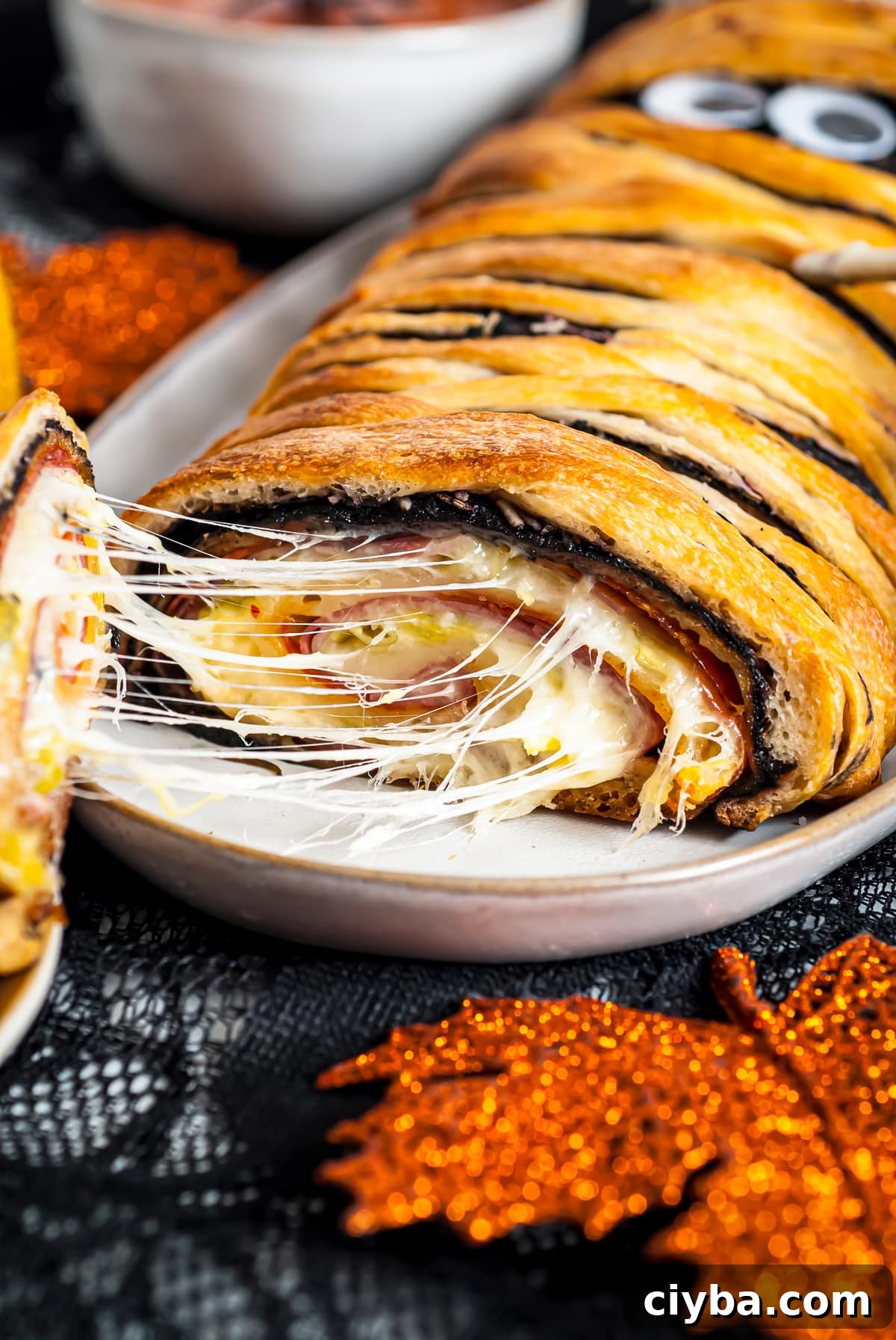 Piece of the Stromboli being pulled showing the cheese and inside filling.