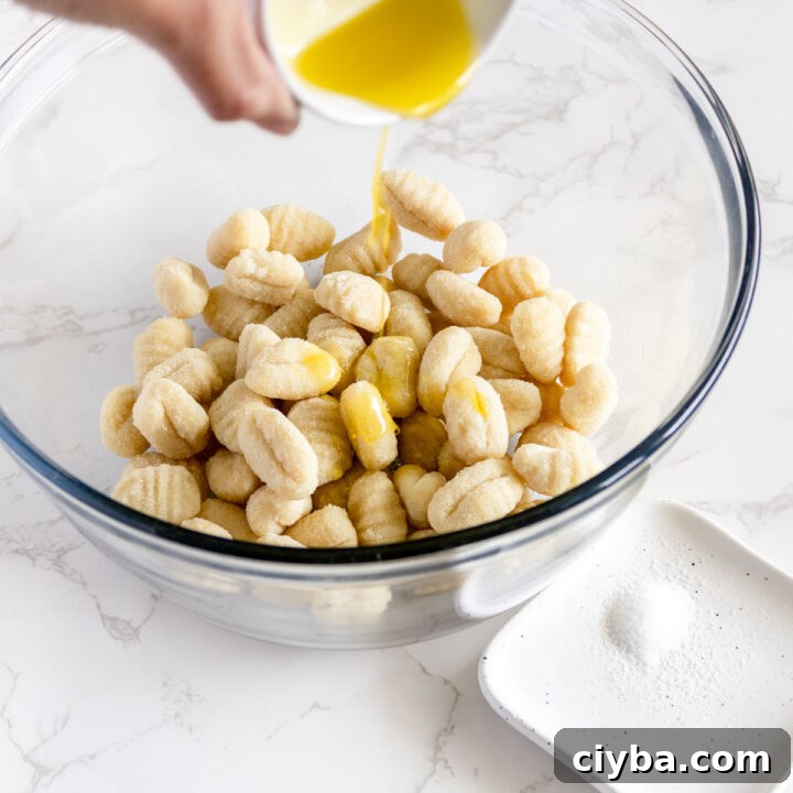 Crispy Air Fryer Gnocchi with Garlic Butter and Parmesan 4 gnocchi in a bowl with olive oil.