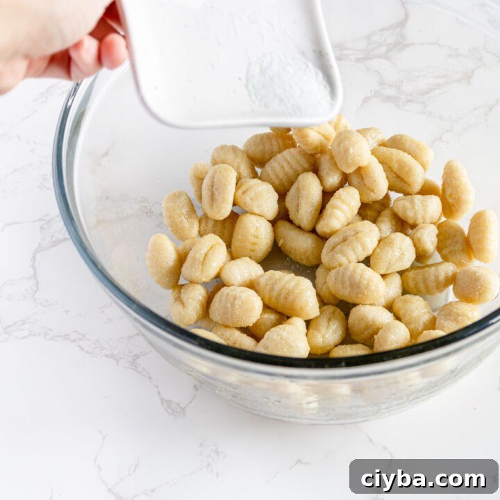 Crispy Air Fryer Gnocchi with Garlic Butter and Parmesan 5 gnocchi in a bowl with olive oil and salt.