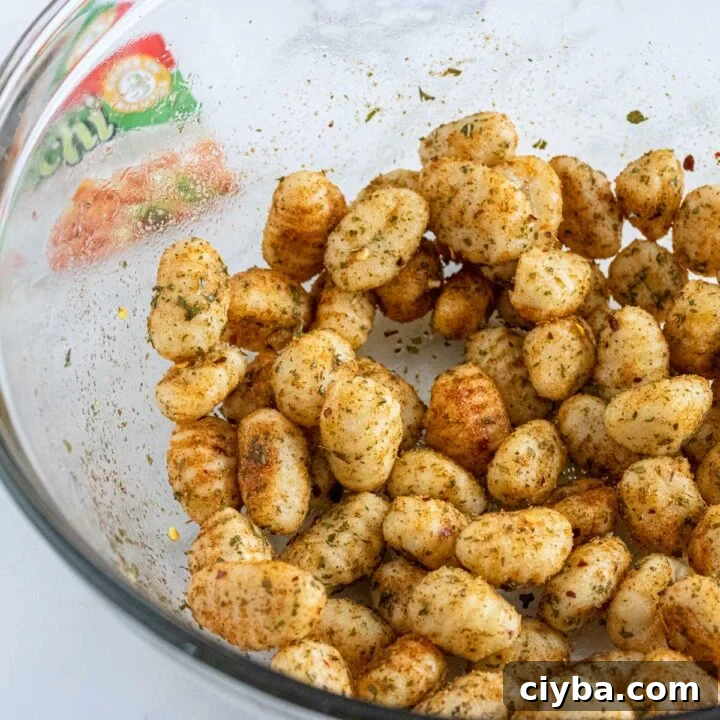 Crispy Air Fryer Gnocchi with Garlic Butter and Parmesan 6 seasoned gnocchi in a bowl.