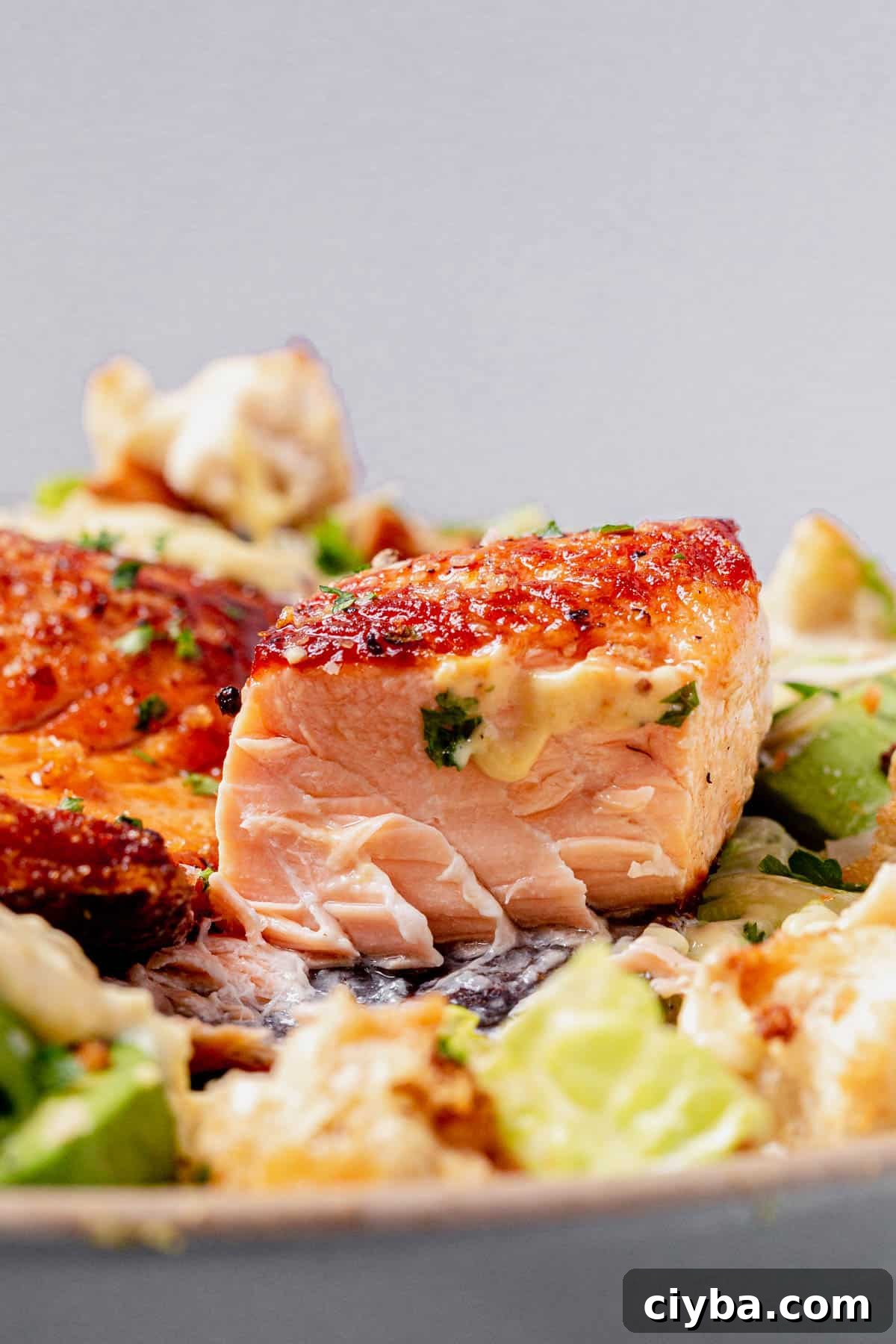 The center of a flaky salmon filet on a Caesar salad