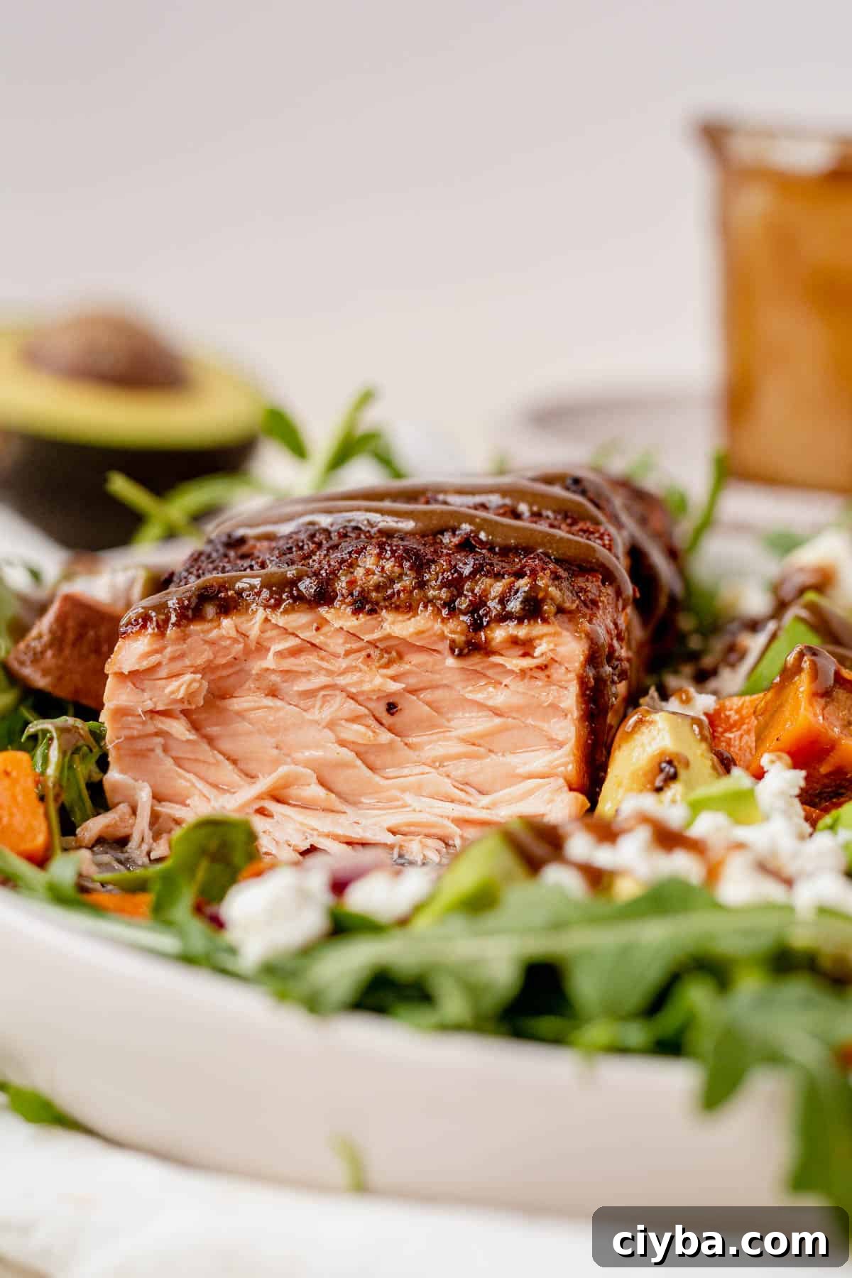 The inside of a piece of flaky salmon on a bed of arugula