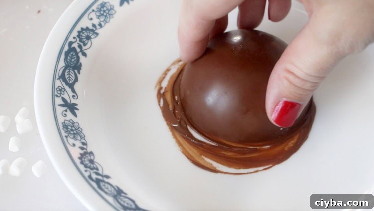 pressing bottom half of bomb against a hot plate to melt the edge