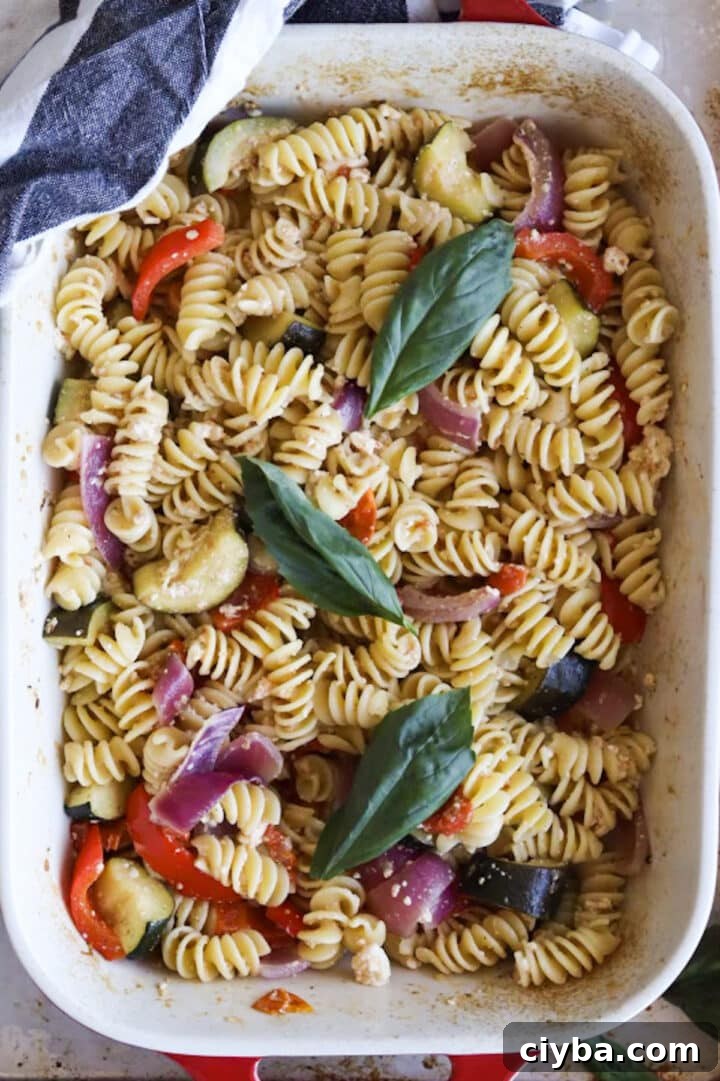 Baking dish containing baked feta pasta with more vegetables