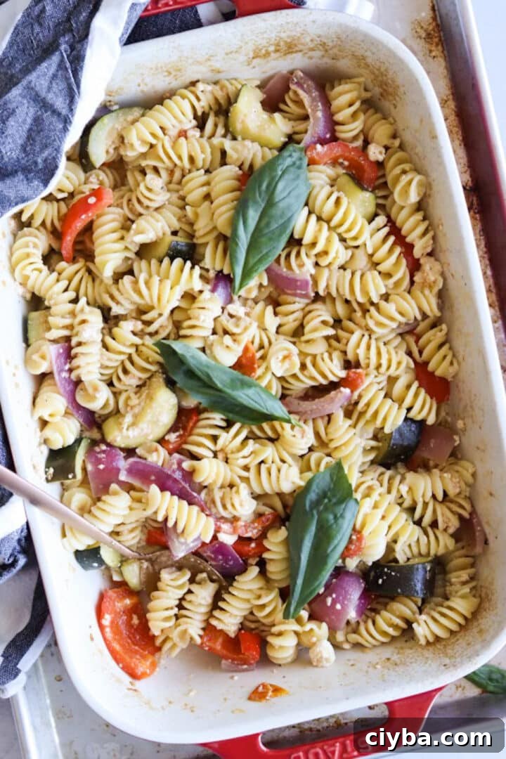 Baking dish with finished baked feta pasta and a gold spoon