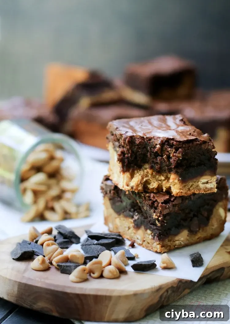 Chewy Peanut Butter Blondie Brownies 10 A two stack of Peanut Butter Blondie Brownies with chocolate chips peanuts and a bite taken