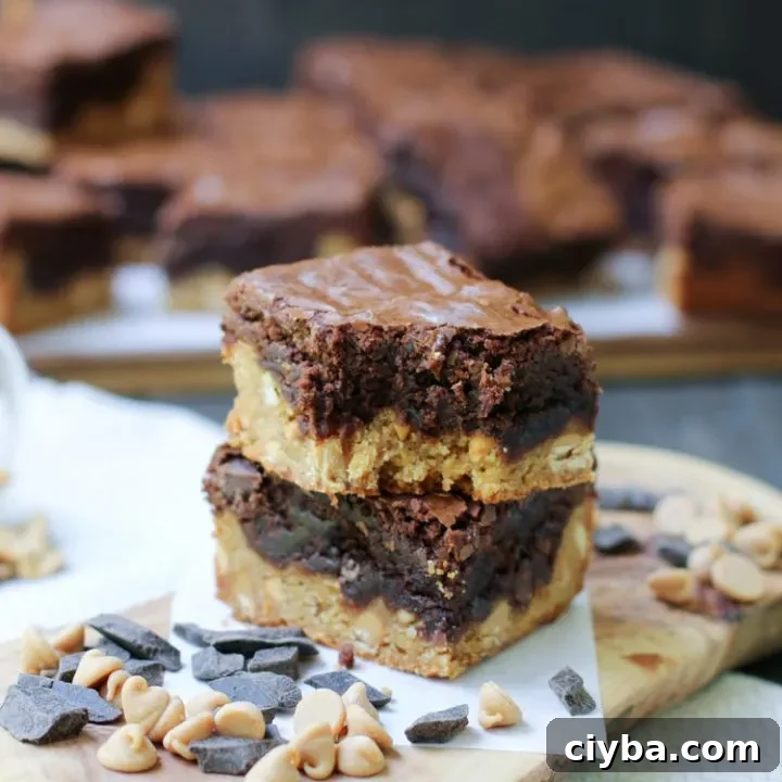 A two stack of Peanut Butter Blondie Brownies with chocolate chips and a bite taken