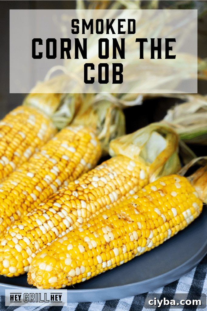 Four ears of smoked corn on the cob on a gray plate with text overlay - Smoked Corn on the Cob.