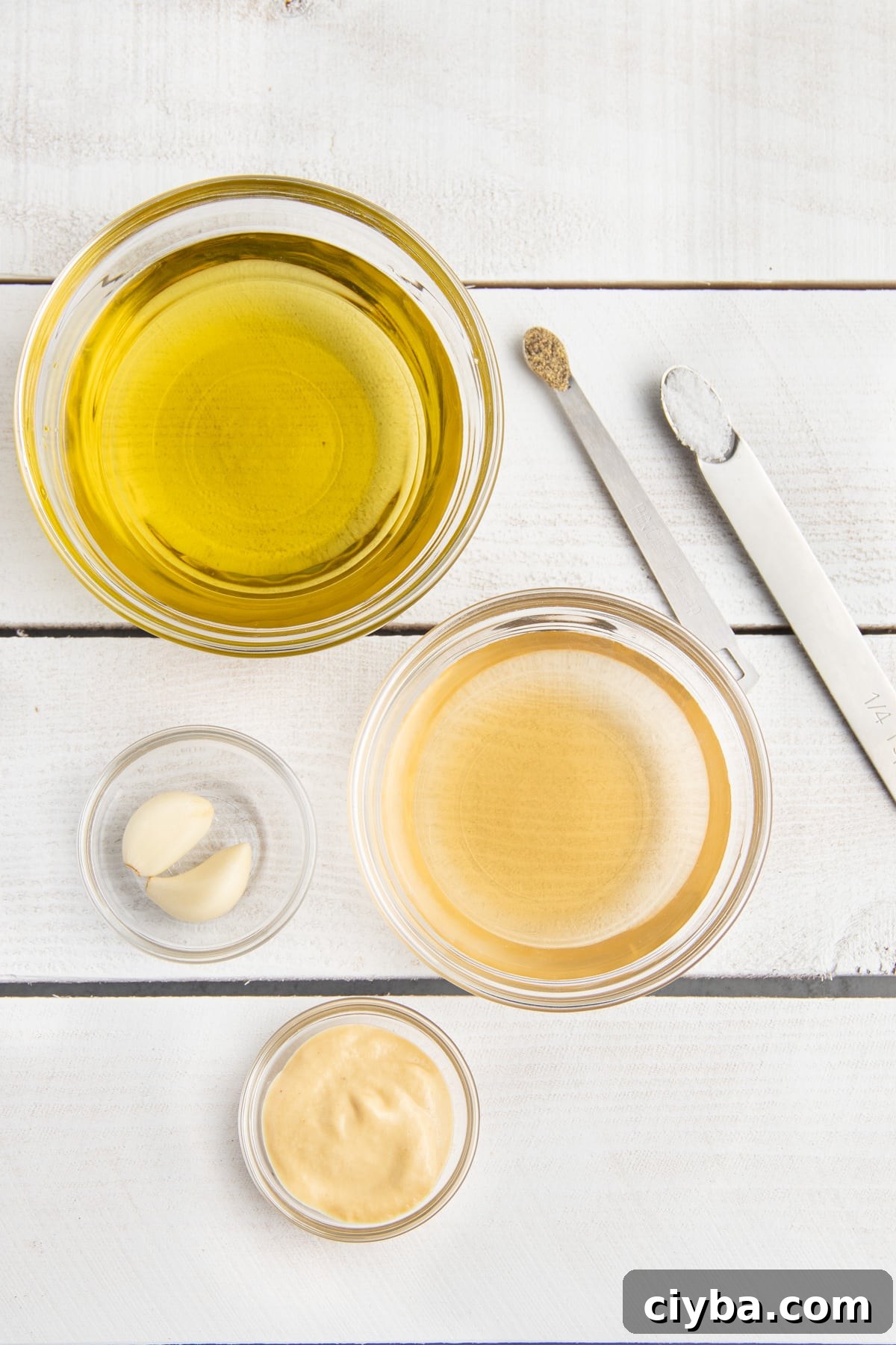 Picture of all ingredients to make champagne vinaigrette in individual bowls.