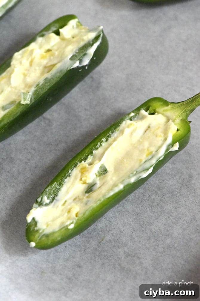 Pineapple Jalapeno Popper Recipe - Sweet and spicy, these jalapeno poppers are made with a pineapple cream cheese spread, wrapped with bacon and baked to perfection!