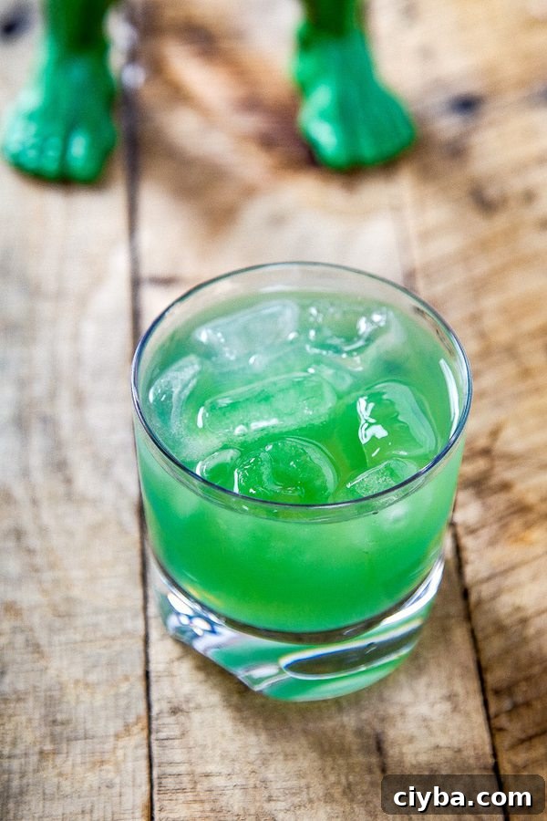 Incredible Hulk Cocktail: Classic Green Cognac Drink 2 a green incredible hulk drink with ice in a whiskey glass.