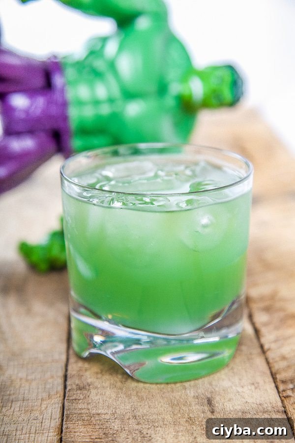 Incredible Hulk Cocktail: Classic Green Cognac Drink 4 a green cocktail with a hulk figurine in the background.