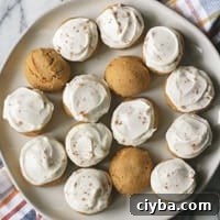 frosted pumpkin cookies on a cream plate