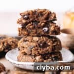 A stack of vegan pumpkin oatmeal cookies with melty chocolate chips.