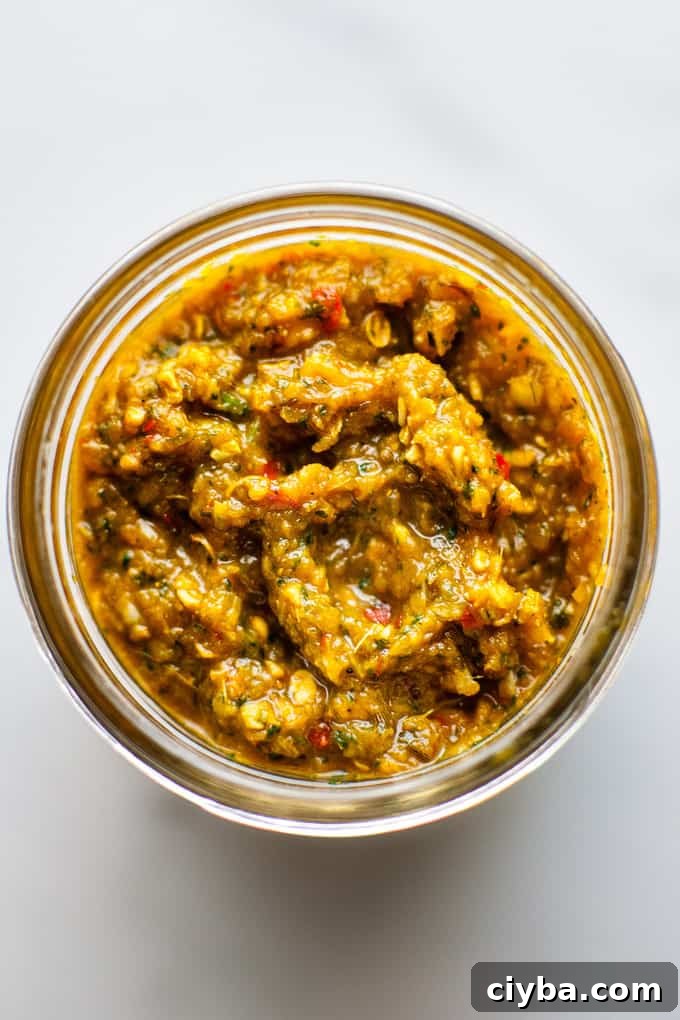 Jar of Thai yellow curry paste on a white background.
