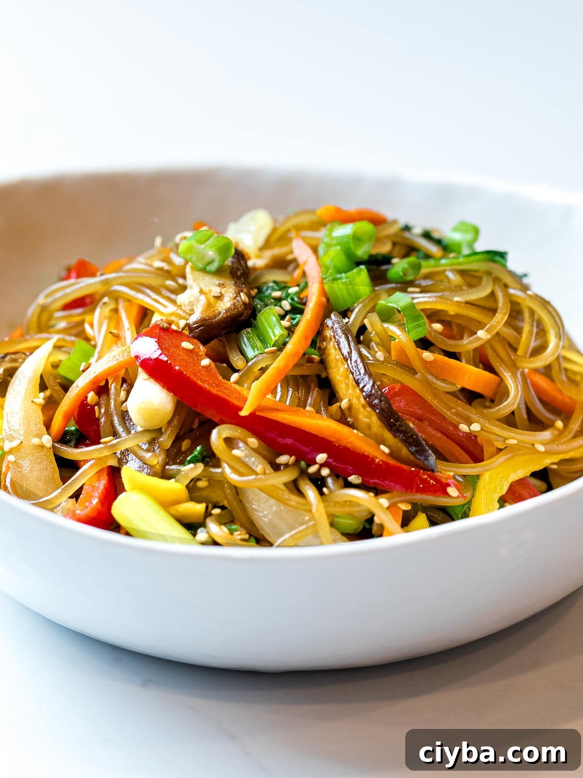 Authentic Japchae: Korean Glass Noodle Stir Fry Recipe 13 close up of Korean glass noodles, japchae, with colorful stir fried vegetables