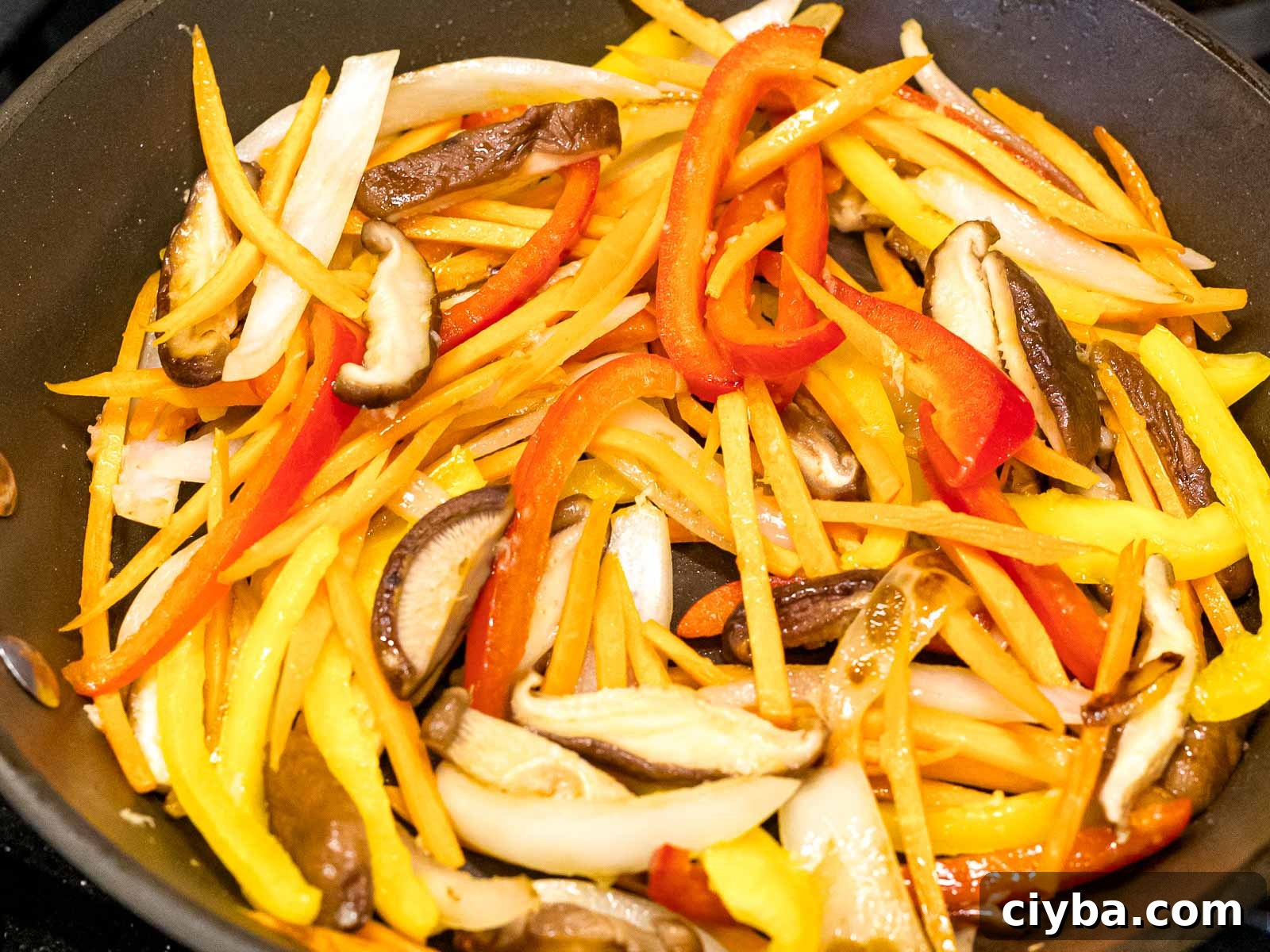 Authentic Japchae: Korean Glass Noodle Stir Fry Recipe 10 stir fried carrots, shiitake mushrooms, and bell peppers in a pan