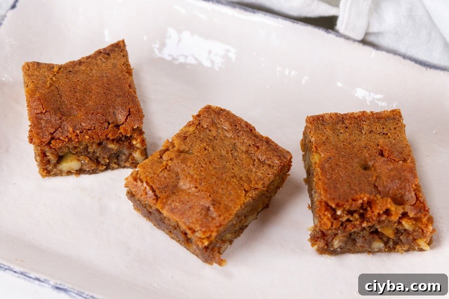 three coffee walnut bars on a white plate.