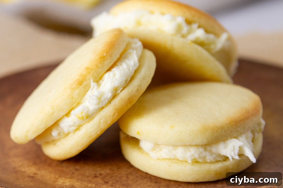 3 lemon sandwich cookies in a stack on a brown plate.