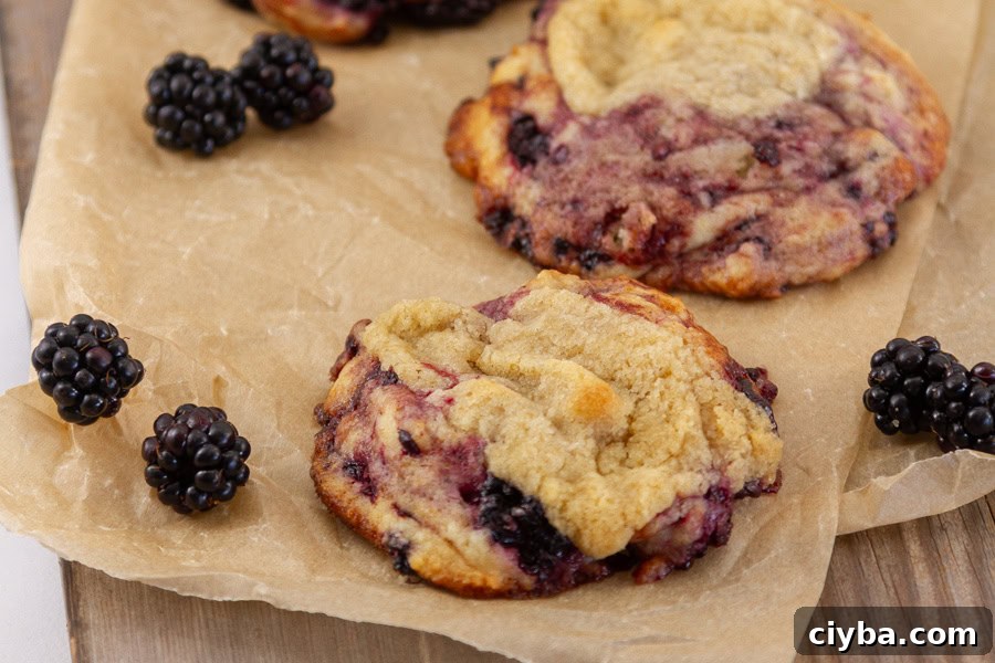 blackberry muffin cookie on brown parchment paper with blackberries around.
