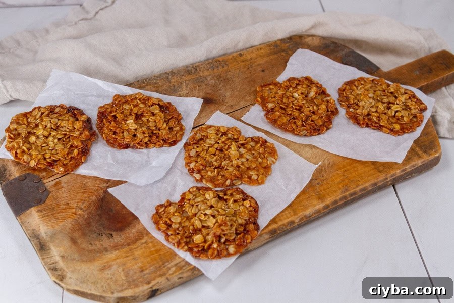 horizontal crop of cookies on sheets of parchment paper on a wooden serving platter.