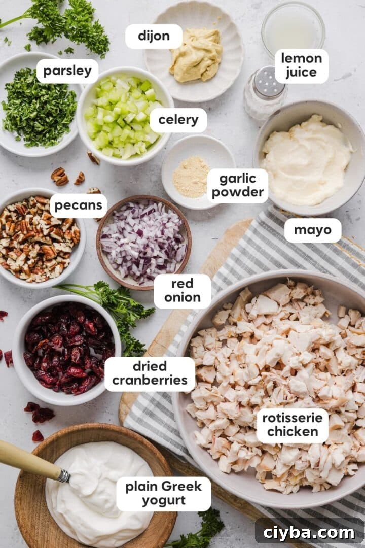 Cranberry Pecan Chicken Salad with Maple-Dijon Vinaigrette 3 Ingredients for cranberry pecan chicken salad displayed in small bowls on a marble counter top.