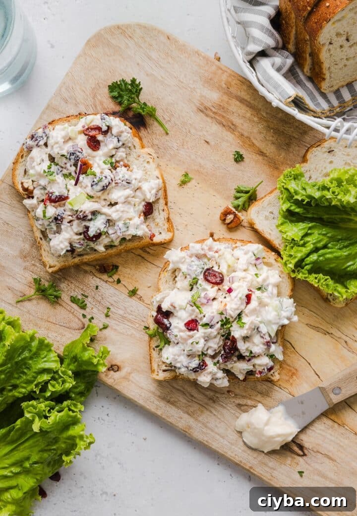 Cranberry Pecan Chicken Salad with Maple-Dijon Vinaigrette 6 Cranberry pecan chicken salad on open-faced bread on a wooden cutting board.