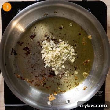 Garlic sauteing in a pan with olive oil.